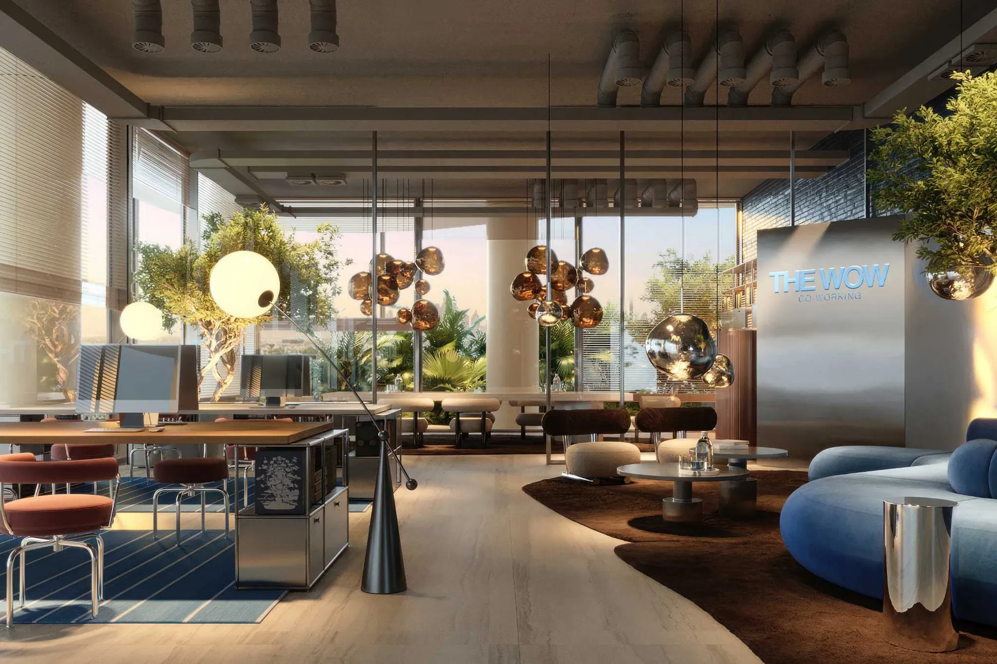Coworking space with desks, computers, trees and a blue lounge sofa