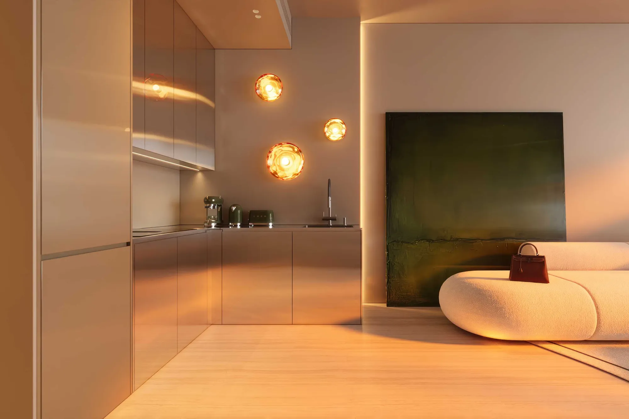 Warm living room with cream sofa beside a steel Italian kitchen